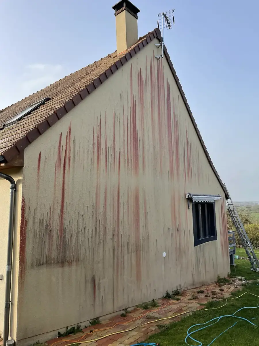 Grand pignon couvert de coulures rouges avant traitement en Eure-et-Loir