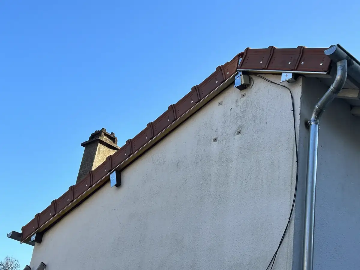Descente de gouttière en zinc et rive habillée le long d'un pignon par Renaud Rénov en Eure-et-Loir