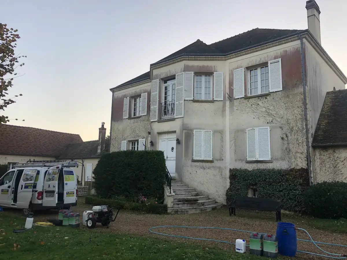 Façade d'entrée d'un haras à Guainville grisée par les algues avant nettoyage