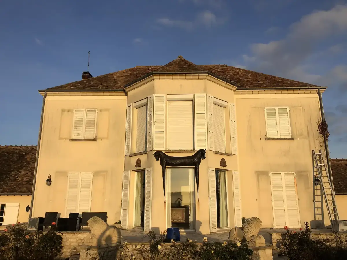 Mur de façade verdi et encrassé avant nettoyage en Eure-et-Loir